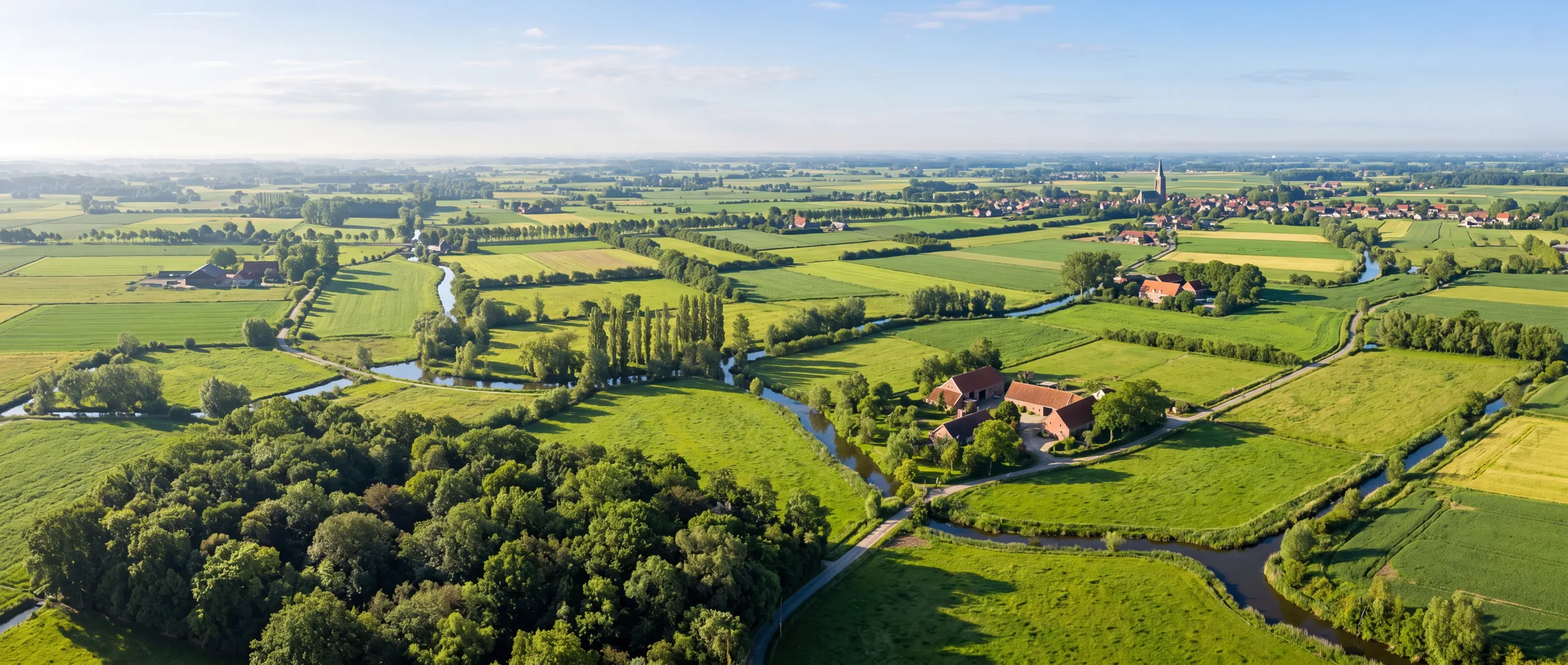Luchtfoto van een fris Vlaams landschap met groene velden, houtkanten, bomenrijen en waterlopen - landschapsproject Studio Buiten